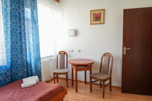 a room with a bed and a table and two chairs at Hotel Sutoris in Bochnia
