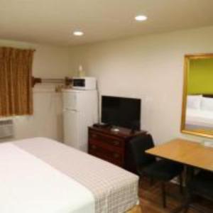 a bedroom with a bed and a desk and a television at Americas Express Inn Rocky Mount in Rocky Mount