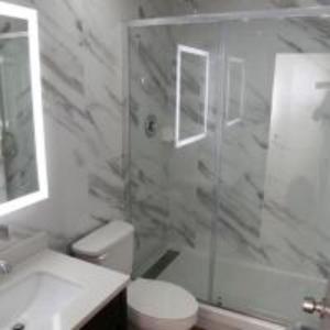 a bathroom with a shower and a toilet and a sink at Americas Express Inn Rocky Mount in Rocky Mount +18 photos