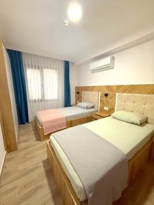a hotel room with two beds and a window at ÇAMLIK APART in Ayvalık
