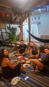 a group of people sitting around a table with food at Bamboo Craft Homestay in Sangyang