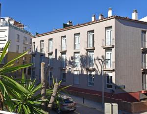 a row of buildings with a car parked in front at Apartamentos AR Dosjoimi in Lloret de Mar