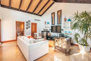 a living room with a white couch and a tv at Gorgeous PH at Puerto Bahia in Santa Bárbara de Samaná