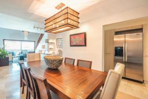 a dining room with a wooden table and chairs at Gorgeous PH at Puerto Bahia in Santa Bárbara de Samaná +15 photos