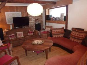 a living room with a couch and a table at chambre pour 2 à 4 personnes ,balcon in Mont-Saxonnex