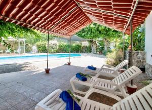 a group of chairs under an umbrella next to a pool at Geodesic sanctuary with a heated pool in Chiconcuac