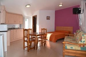 a kitchen and living room with a table and a bed at Apartamentos AR Dosjoimi in Lloret de Mar