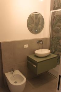 a bathroom with a sink and a toilet and a mirror at Bonbon in Treviso +8 photos