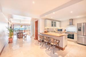 a kitchen with a island with chairs and a table at 3BR Beachfront townhouse at Puerto Bahia in Santa Bárbara de Samaná