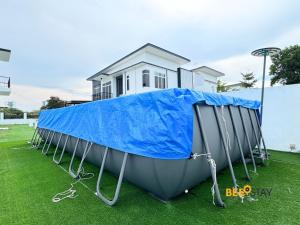 a boat covered in a blue tarp in front of a house at Desaru Arcadia Double Storey House 11-16 Pax 5 Mins to Desaru Beach in Bandar Penawar