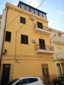 a yellow building with a white car parked in front of it at Terrasini 218 in Terrasini +7 photos