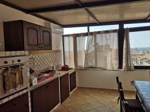 a kitchen with wooden cabinets and a table and a window at Terrasini 218 in Terrasini