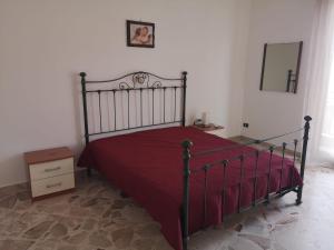 a bedroom with a bed with a red bedspread at Terrasini 218 in Terrasini