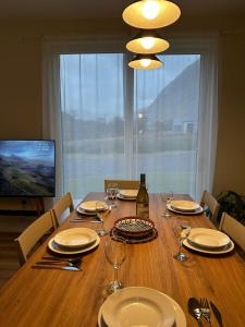 a dining room table with plates and wine glasses at Auch - Cottages in Bridge of Orchy