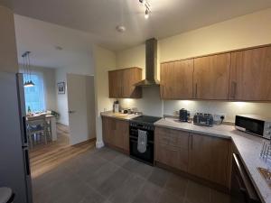 a kitchen with wooden cabinets and a stove top oven at Auch - Cottages in Bridge of Orchy
