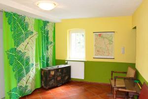 a room with green and yellow walls and a table at Dat Uhlenhus in Bohlsen +17 photos