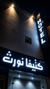a sign for a store with lights on it at فندق كتيفا نورث in Arar
