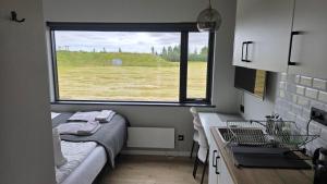 a small room with a bed and a window at Landbrot Guesthouse in Kirkjubæjarklaustur +5 photos