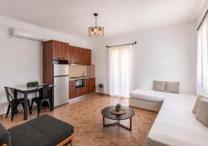 a living room with a couch and a table at Aigaion Aetherium Apartments in Livadakia