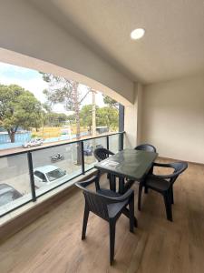 a dining room with a table and chairs and a large window at ÇAMLIK APART in Ayvalık