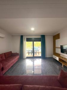a living room with a couch and a television at ÇAMLIK APART in Ayvalık