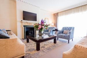 a living room with a fireplace and a table with flowers at 9 Hertford Street Mayfair in London