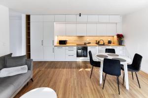 a kitchen and a living room with a table and chairs at Park & Town Apartment in Drawsko Pomorskie