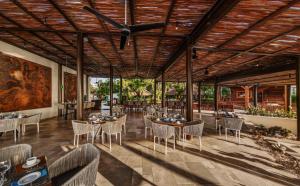 a dining room with tables and chairs and a ceiling at Dreams Riviera Cancun Resort & Spa - All Inclusive in Puerto Morelos
