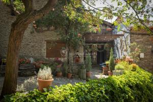 a garden with potted plants and a brick building at La Coberta-Lo Paller del Coc in Rialp