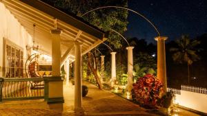 a building with a porch at night with flowers at Hebron Gardens House in Kandy