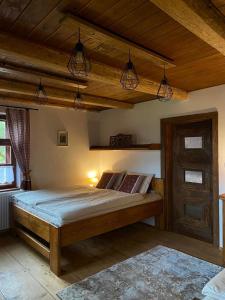 a bedroom with a bed with wooden ceilings and lights at Chalupa Na Bačáku in Frýdek-Místek