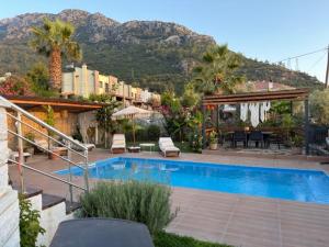 a house with a swimming pool and a table and chairs at Villa Zalin in Ovacik