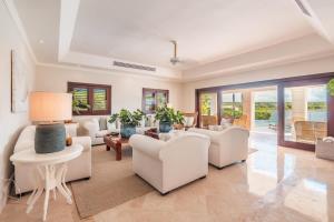 a living room with white furniture and sliding glass doors at Seaside Bliss with pool and spectacular view in Las Minas