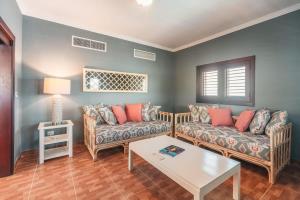 a living room with two couches and a table at Seaside Bliss with pool and spectacular view in Las Minas