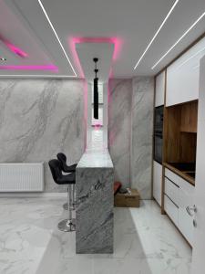 a kitchen with a counter and a chair in a room at NelaLux 2 in Bratunac +2 photos