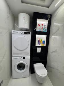 a bathroom with a washing machine and a toilet at NelaLux 2 in Bratunac