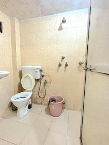 a bathroom with a shower with a toilet and a bucket at Zipcode Kashi in Varanasi