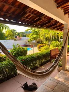 a black cat sleeping in a hammock on a patio at Pousada Alter Villa Suítes in Alter do Chao