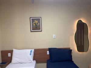 a bedroom with a bed and a guitar on the wall at Hotel Amado in Aracaju