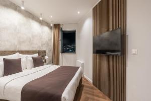 a bedroom with a large bed and a television at Hotel Bulevar Mostar in Mostar