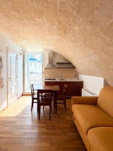 a kitchen and dining room with a table and a couch at Residence Del Casalnuovo in Matera