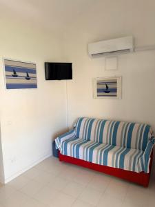a couch in a room with a tv on the wall at Blu 31 Marcelli in Marcelli