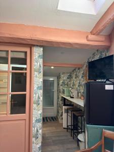 a kitchen with a refrigerator and a table in a room at La chambre de Joséphine in Royan