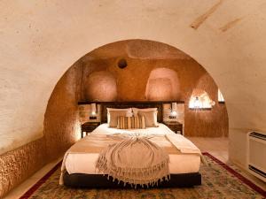 a bedroom with a large bed in a stone wall at Cybele in Cappadocia in Uçhisar +190 photos