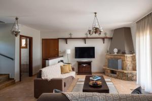 a living room with a couch and a tv at The Grand Panorama Villa in Nea Moudania