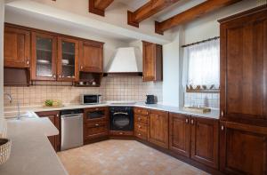 a kitchen with wooden cabinets and a dishwasher at The Grand Panorama Villa in Nea Moudania