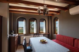 a dining room with a table with a bowl of fruit on it at The Grand Panorama Villa in Nea Moudania
