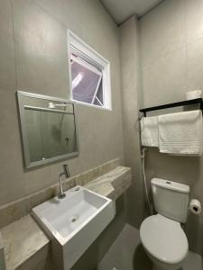 a bathroom with a white toilet and a sink at Hotel Amado in Aracaju +12 photos