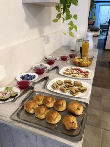 a table with plates of pastries and plates of food at Mare Hotel Apartment in Mar del Plata