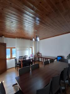 a dining room with wooden ceilings and a table and chairs at Guest House Trojani in Lëpushë